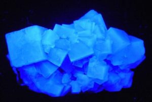 Fluorite glowing under short wave ultraviolet light best UV black light flashlight for minerals