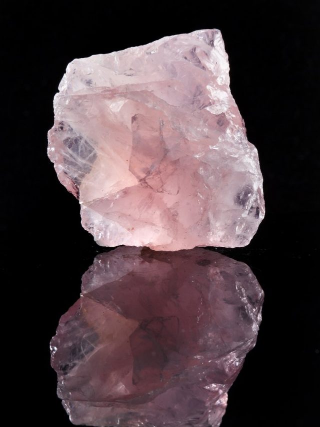 Natural,Rose,Quartz,Crystal,With,Reflection,On,Black,Surface,Background